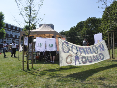 A banner saying 'Common Ground' in front of a field and a screen-printing tent